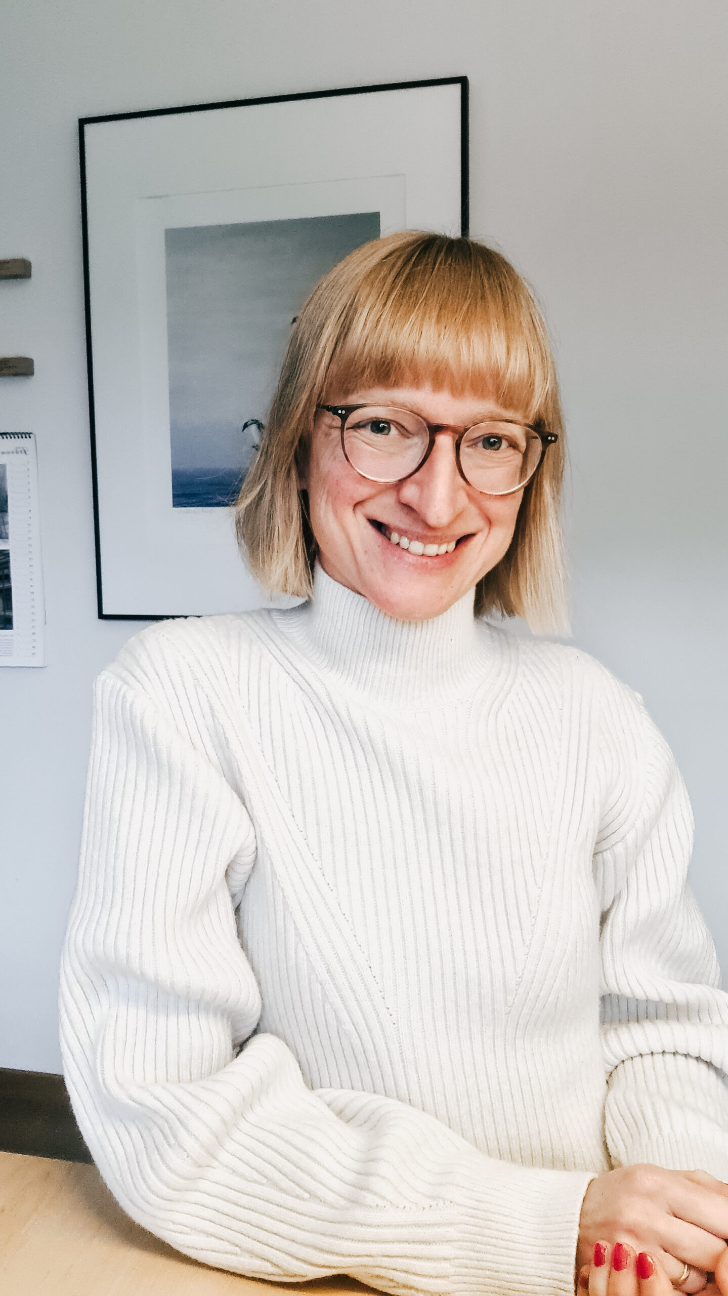 Gelingend Altern mit Marlis Schorcht Marlis Schorcht sitzt am Schreibtisch und lächelt in die Kamera